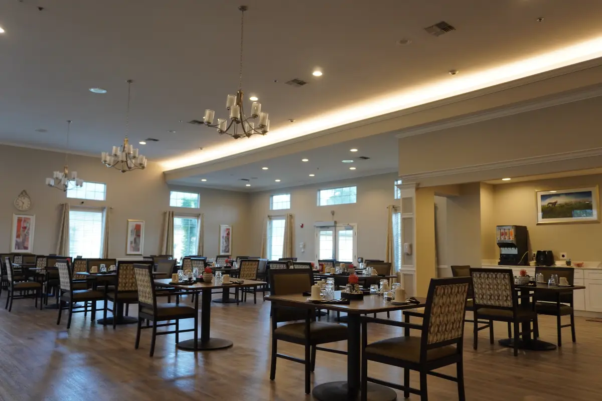 A second dining space with tables set beside tall windows