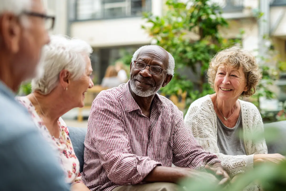 Two residents talking together in a sunlit common room